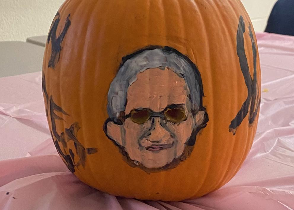 Pumpkin decorated with a man's head, glasses and gray hair