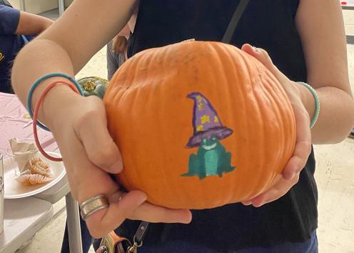 LUCK student with her pumpkin decorated with frog and purple witches hat with yellow stars